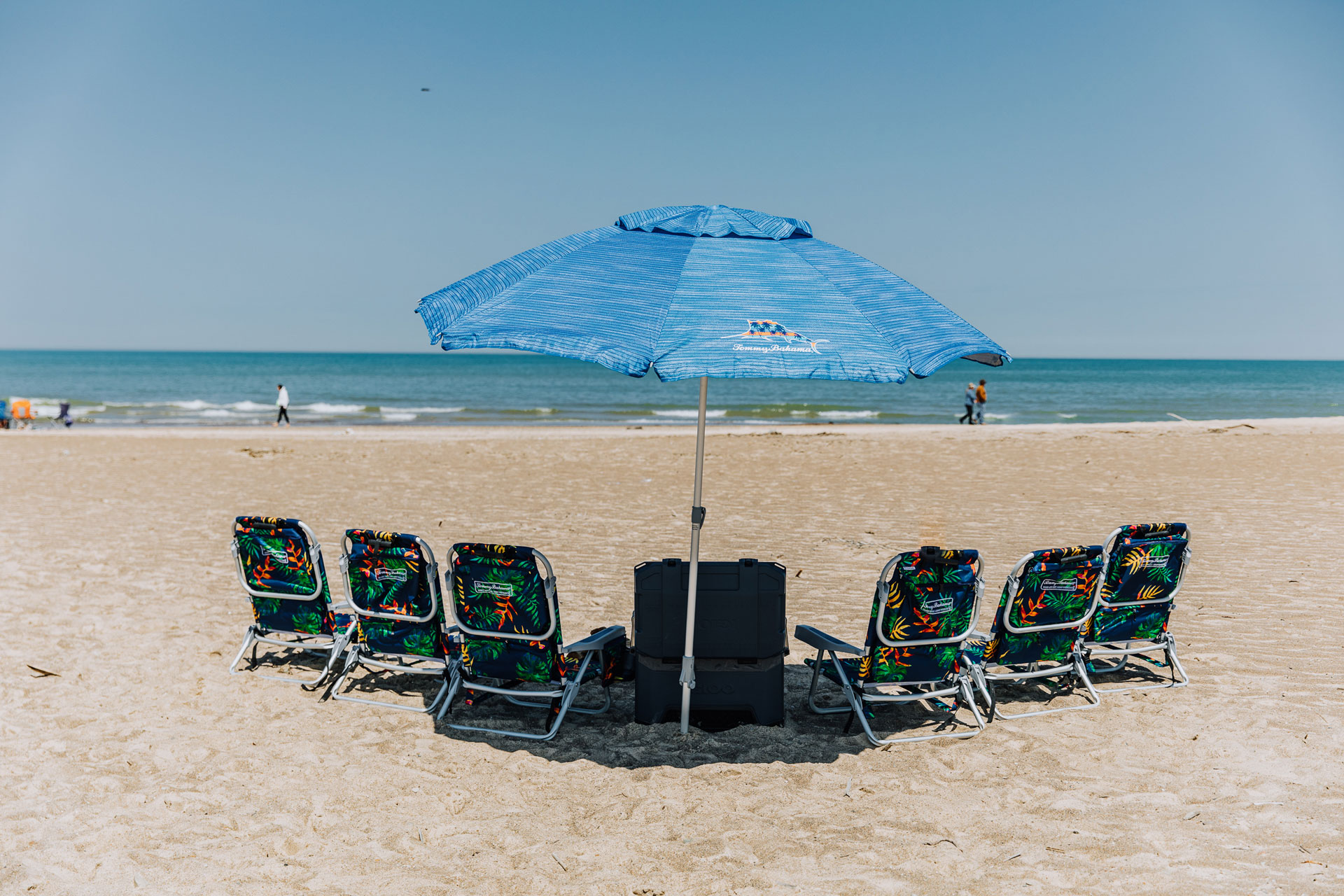 beach chairs under an umbrella on the beach